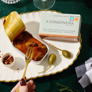 An opened tin of A Conserveira Mejillones Fritos en Salsa de Vieira