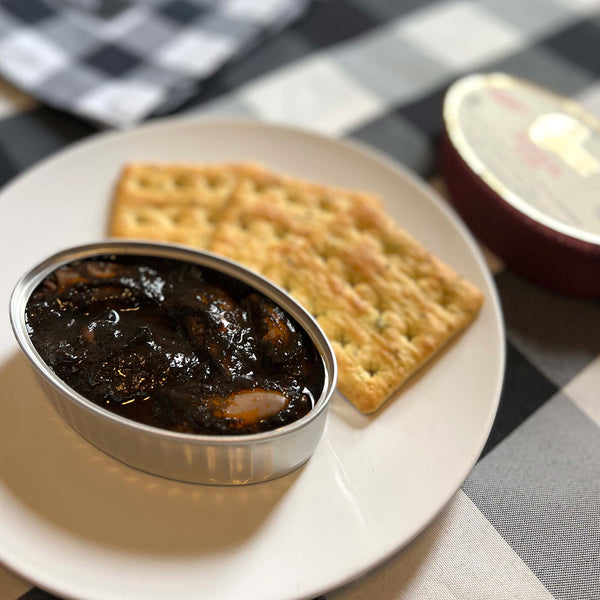 Conservas de Cambados Stuffed Squids in Ink served in an opened tin, with crackers