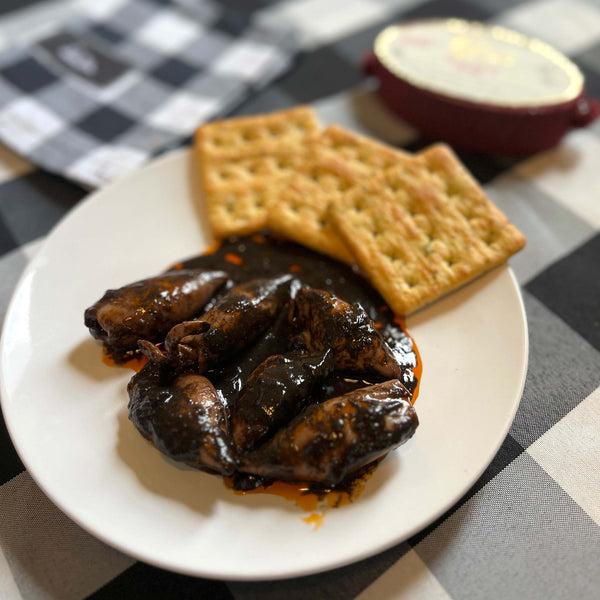 Conservas de Cambados Stuffed Squids in Ink served on a plate with crackers