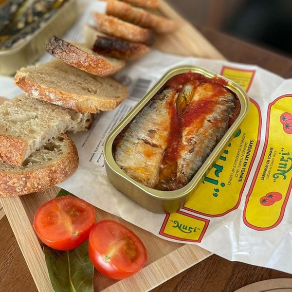 Nuri Sardines in Tomato Sauce served in an opened tin with bread and tomatoes