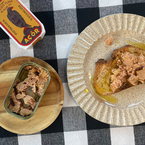 Acor Spiced Tuna served on bread with olive oil - the opened tin sits beside the plate