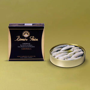 Ramón Peña Small Sardines in Olive Oil with Padrón Peppers - an opened tin beside the packaging