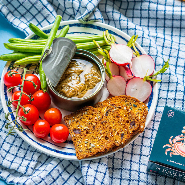 An opened tin of Seed to Surf Mushroom Snow Crab, served with tomatoes, radishes and green beans